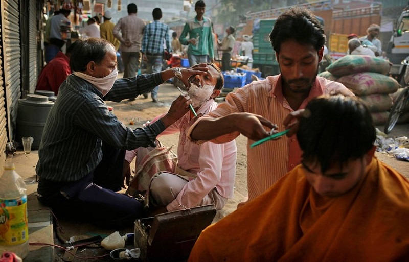 Haircuts are administered by street barbers at a marketplace in New Delhi, India, on November 9, 2012.KevinFrayerAP
